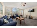 Inviting living room featuring large arched window, comfortable seating, and a ceiling fan at 8716 Rain Forest Pl # D, Kissimmee, FL 34747