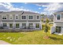 Rear view of townhomes, showing private patios and grassy areas at 2023 Claudia Ln, Kissimmee, FL 34741