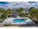 Community pool with a covered patio and surrounding fence at 2023 Claudia Ln, Kissimmee, FL 34741