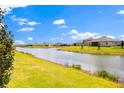 Scenic view of a green backyard sloping down to a tranquil lake on a sunny day at 2949 Nottel Dr, St Cloud, FL 34772
