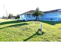 Modest single-story home with a blue exterior, small porch, and spacious lawn at 101 Whitehall Way, Kissimmee, FL 34758