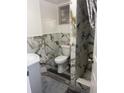 Nicely remodeled bathroom featuring modern marble style tile and a shower with glass door at 7024 Moderna Way, Orlando, FL 32822