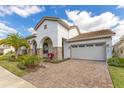 Beautiful home boasts a brick-paved driveway, lush landscaping, stone accents, and a two-car garage at 13809 Abberwick Dr, Orlando, FL 32832