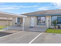 Charming condo with blue trim and outdoor patio area, complemented by an adjacent covered parking space at 392 Winter Ridge Blvd # 105, Winter Haven, FL 33881