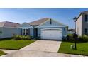Single-Gathering home exterior with blue siding, brown shutters, well-kept lawn, and two car garage at 1687 Park Side Ave, Kissimmee, FL 34744