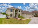 Charming two-story home featuring a three-car garage, landscaped yard, and a welcoming entrance at 18035 Cadence St, Orlando, FL 32820