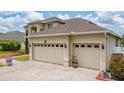 Spacious three-car garage with decorative doors, exterior lighting, and a paved driveway at 18035 Cadence St, Orlando, FL 32820