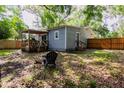 Private backyard with a wooden deck, fenced perimeter, and mature trees providing ample shade at 527 Noble Ave, Davenport, FL 33837