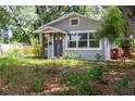 Inviting single-story home featuring a covered porch, large windows, and mature trees for shade at 527 Noble Ave, Davenport, FL 33837