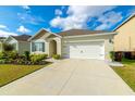Attractive one-story home featuring tidy landscaping, a driveway, and an attached two-car garage at 527 Noble Ave, Davenport, FL 33837