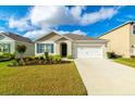 Inviting single-story home featuring a manicured lawn, a driveway, and an attached two-car garage at 527 Noble Ave, Davenport, FL 33837
