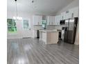 Modern kitchen with white cabinets, stainless steel appliances, and an island at 6817 Sw 131St Pl, Ocala, FL 34473