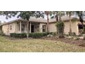 Tan house with covered porch, landscaping, and a two-car garage at 753 Largo Pass, Poinciana, FL 34759