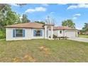 Inviting single-story home featuring a manicured lawn, white exterior, and a two-car garage at 314 Dagama Ct, Kissimmee, FL 34758