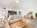 Open concept living and dining area with beige sofa and wooden coffee table at 663 Irvine Ranch Rd, Poinciana, FL 34759