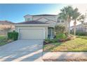 Charming two-story home with a well-manicured lawn, tile roof, and inviting curb appeal at 4191 Oaktree Drive, Davenport, FL 33837