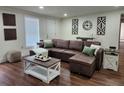 Living room with brown leather sofa, stylish decor and hardwood floors at 4950 Nova Ave, St Cloud, FL 34773