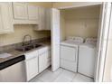 Kitchen featuring white cabinets, granite countertops, and a laundry area at 1069 Universal Rest Pl, Kissimmee, FL 34744