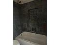 Bathroom with gray tiled walls and a shower head at 1700 Kentucky Ave, St Cloud, FL 34769
