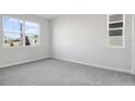 Bright bedroom with gray carpet, neutral walls, and large windows at 1740 Carnelian St, Deland, FL 32720