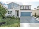 Two-story home with gray and blue exterior, two-car garage, and landscaping at 1740 Carnelian St, Deland, FL 32720