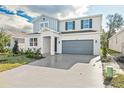 Two-story home with gray and blue exterior, two-car garage, and landscaping at 1740 Carnelian St, Deland, FL 32720