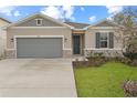 Charming single-story home featuring a gray front door and a concrete driveway at 1742 Carnelian St, Deland, FL 32720