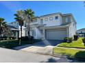 Two-story house with gray and white exterior, three-car garage, and palm trees at 3850 Oakville Ave, Kissimmee, FL 34741