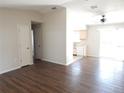 Open-concept living room featuring laminate flooring, ceiling fan, and a view into the kitchen at 4815 Jay Dr, St Cloud, FL 34772