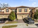 Tan three-story townhome with brown roof and two-car garage at 8121 Roseville Blvd, Davenport, FL 33896