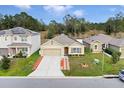 Aerial view of a tan house on a tree-lined street at 965 Shady Tree Ln, Davenport, FL 33897