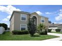 Two-story house with tan exterior, landscaping, and a two-car garage at 137 Milestone Dr, Haines City, FL 33844