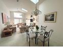 Bright dining area with a glass table and four chairs, adjacent to the living room at 2511 La Jolla Trl, Kissimmee, FL 34747