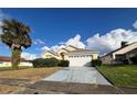 House exterior showcasing a two-car garage and palm tree at 2511 La Jolla Trl, Kissimmee, FL 34747