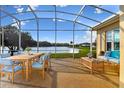 Relaxing screened patio features comfortable seating and dining, with peaceful lake views at 256 New River Dr, Poinciana, FL 34759