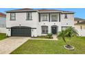 Two-story house with white exterior, black accents, and a two-car garage at 269 Beckenham Dr, Kissimmee, FL 34758