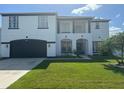 Two-story house with white exterior, black accents, and a two-car garage at 269 Beckenham Dr, Kissimmee, FL 34758