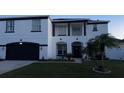 Two-story house with white exterior, black accents, and a two-car garage at 269 Beckenham Dr, Kissimmee, FL 34758