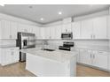 Modern kitchen featuring white cabinets, stainless steel appliances, and a large center island at 1695 Sugarbelle Cir, Mascotte, FL 34753