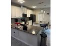 Modern kitchen with white cabinets, gray countertops, and island at 2986 Aqua Virgo Loop, Orlando, FL 32837