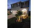Charming two-story home with landscaped yard, walkway, and lit up palm tree at 2459 Taloncrest Ct, Eagle Lake, FL 33839