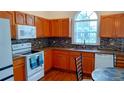 Well-equipped kitchen with stainless steel appliances, tiled backsplash, and warm toned cabinets at 2645 Oneida Loop, Kissimmee, FL 34747
