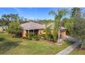 Single story house with a large yard and palm trees at 512 Heartwell Dr, Poinciana, FL 34759
