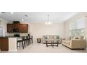 Open-concept living room featuring neutral decor, tile flooring, and seamlessly connected to the kitchen at 9475 Randal Park Blvd, Orlando, FL 32832