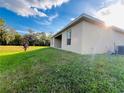 Side view of house highlighting the patio and backyard landscaping at 1421 Swift Ct, Poinciana, FL 34759