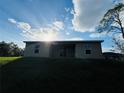 Rear view of house showcasing a covered patio and lush landscaping at 1421 Swift Ct, Poinciana, FL 34759