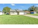 House exterior showcasing a spacious front yard and driveway at 1607 W Oak St, Kissimmee, FL 34741