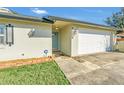 Front view of house with light teal door and attached garage at 1607 W Oak St, Kissimmee, FL 34741