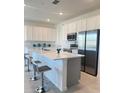 Modern kitchen with white cabinets, stainless steel appliances, and an island at 1625 Hill Park Dr, Deltona, FL 32725