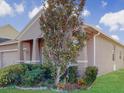 One-story home with a tree and landscaping in front of the house at 1850 Patriot Way, Saint Cloud, FL 34769